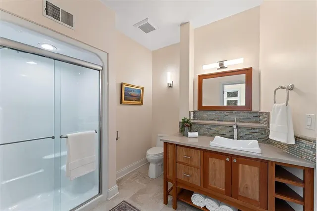 a bathroom with a double vanity sink mirror and toilet