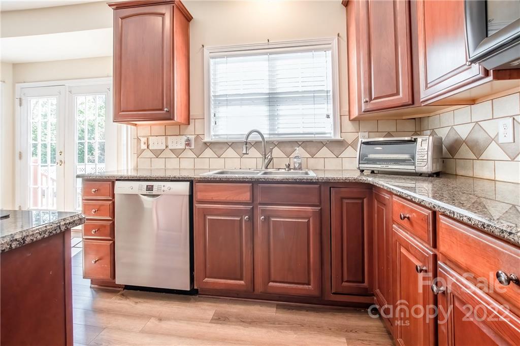 5511 Alexandrite Way Fort Mill, SC 29708 - Photo 12 of 32 a kitchen with stainless steel appliances granite countertop a sink a stove cabinets and wooden floor