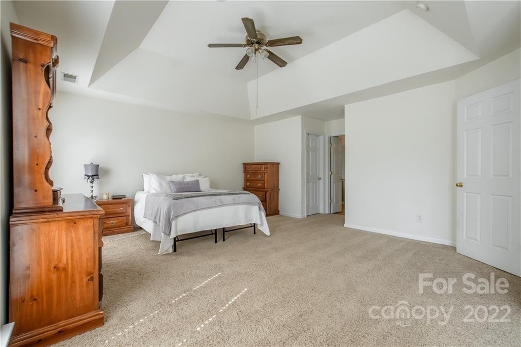 5511 Alexandrite Way Fort Mill, SC 29708 - Photo 15 of 32 a bedroom with a bed and a chandelier