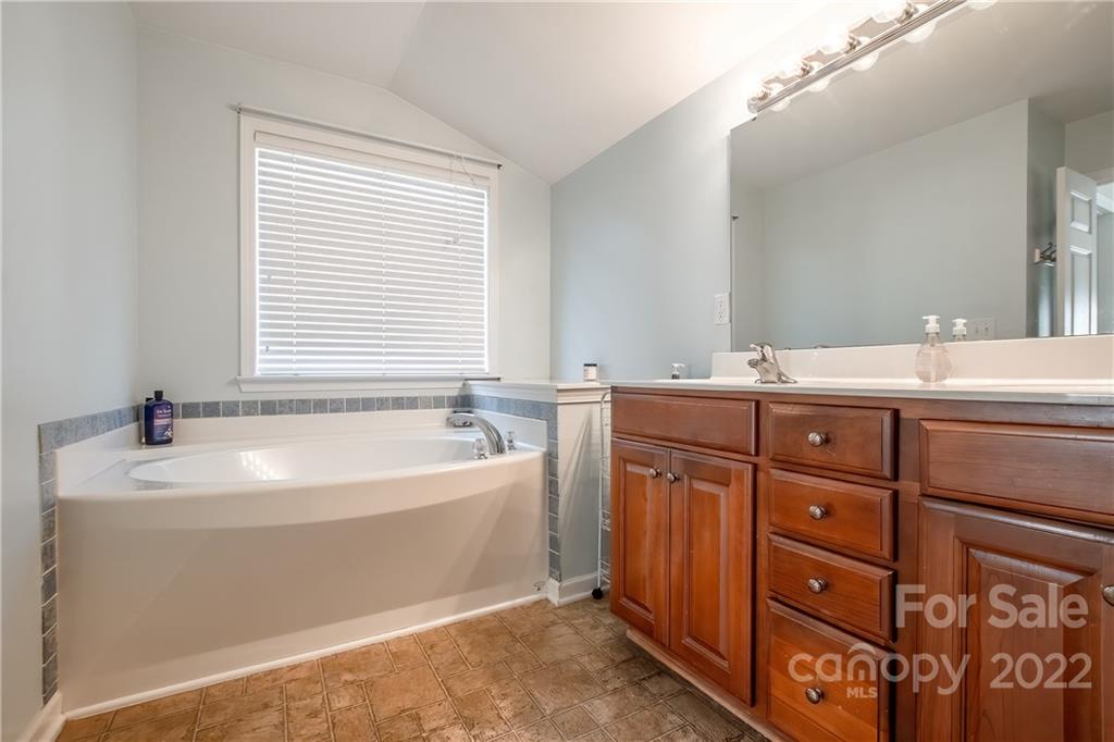 5511 Alexandrite Way Fort Mill, SC 29708 - Photo 19 of 32 a bathroom with a double vanity sink a mirror and a bathtub