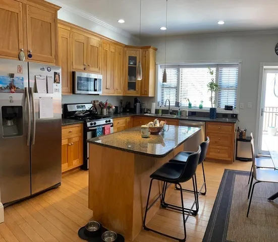 a kitchen with stainless steel appliances granite countertop counter space a sink and a refrigerator