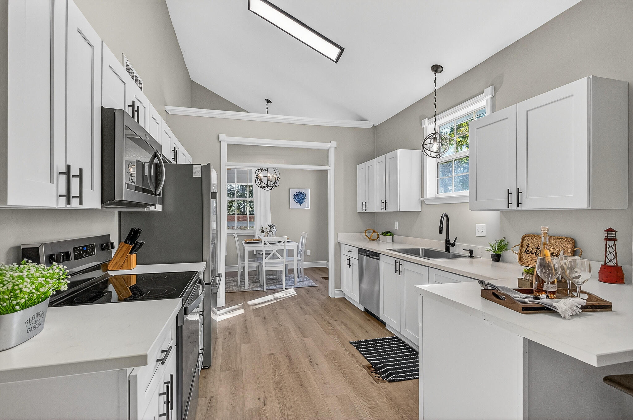 115 Central 6th Street Santa Rosa Beach, FL 32459 - Photo 18 of 56 a kitchen with stainless steel appliances granite countertop a stove top oven a sink dishwasher and cabinets with wooden floor