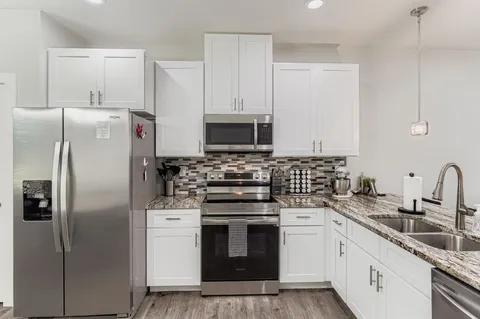 a kitchen with a refrigerator a sink and cabinets