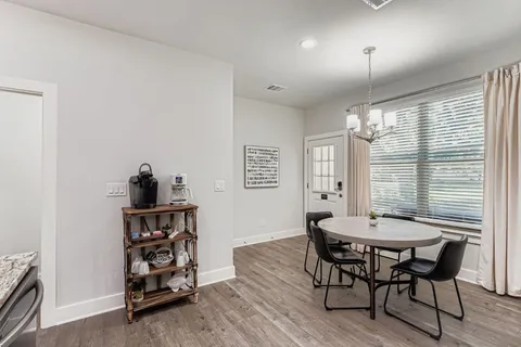 a kitchen with stainless steel appliances wooden floor dining table and chairs