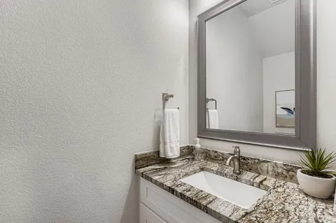 a kitchen with refrigerator a sink cabinets and wooden floor