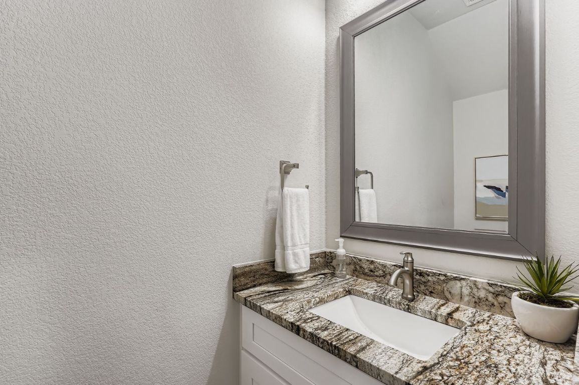 18803 Hogan Circle, Unit 14 Point Venture, TX 78645 - Photo 15 of 40 a bathroom with a granite countertop sink and a mirror