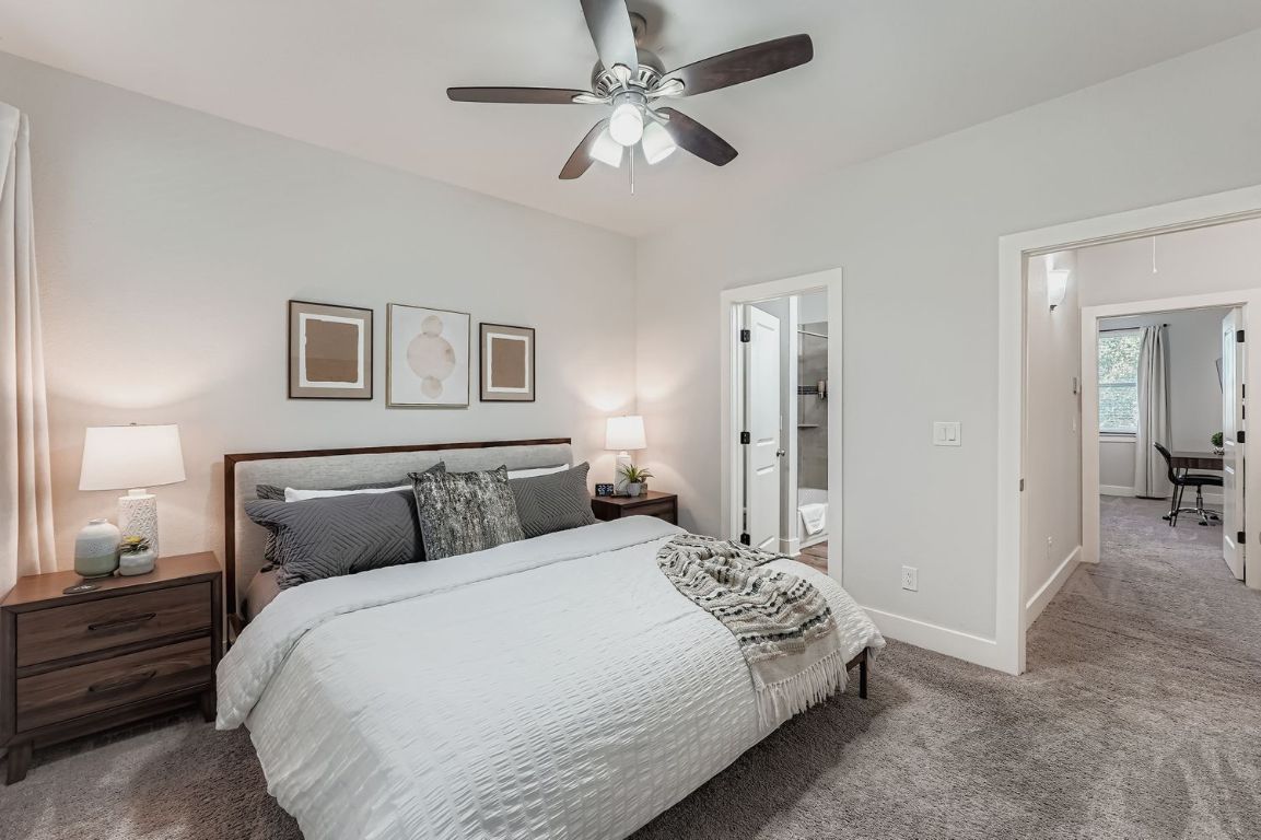 18803 Hogan Circle, Unit 14 Point Venture, TX 78645 - Photo 16 of 40 a bedroom with a bed and a chandelier