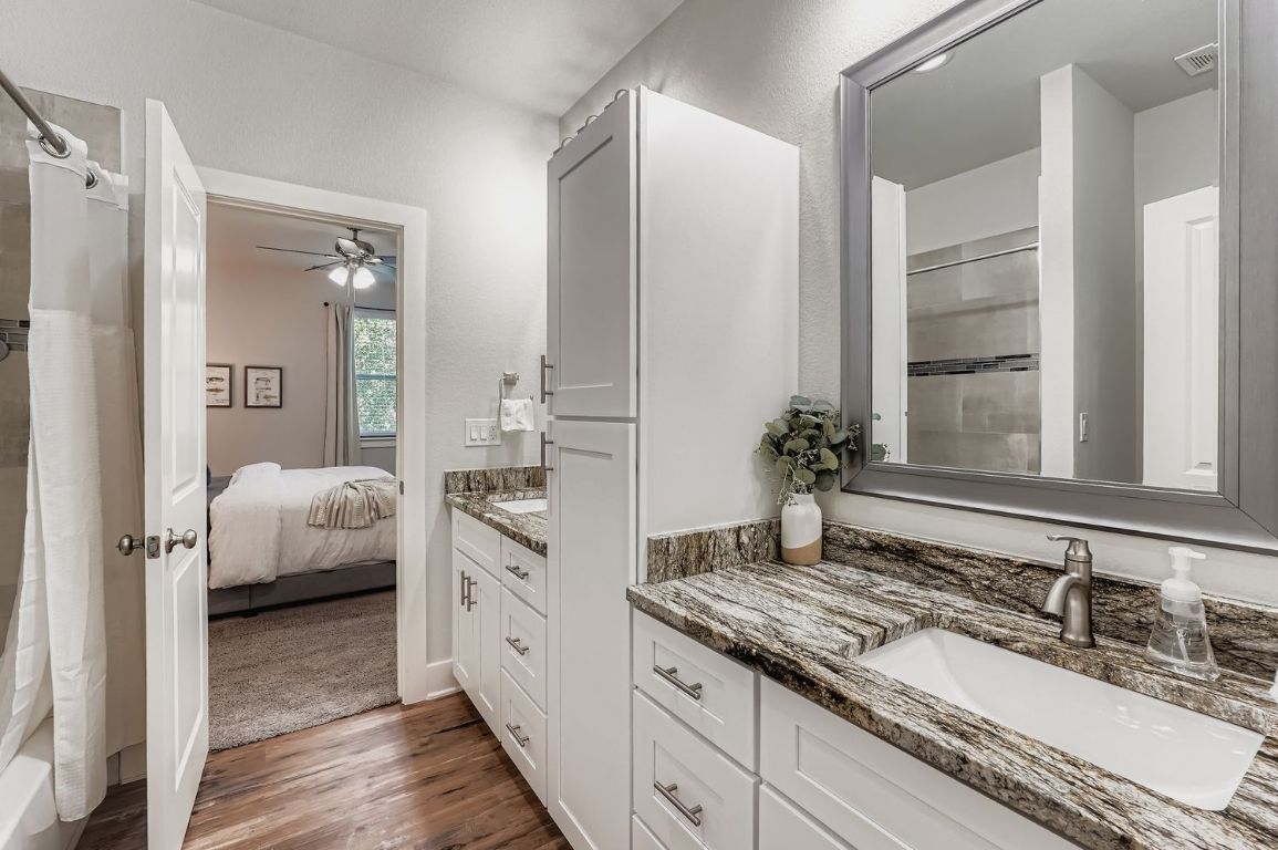 18803 Hogan Circle, Unit 14 Point Venture, TX 78645 - Photo 19 of 40 a spacious bathroom with a granite countertop sink and a mirror