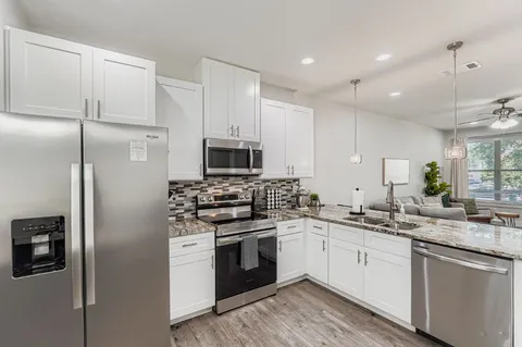 a kitchen with white cabinets and stainless steel appliances