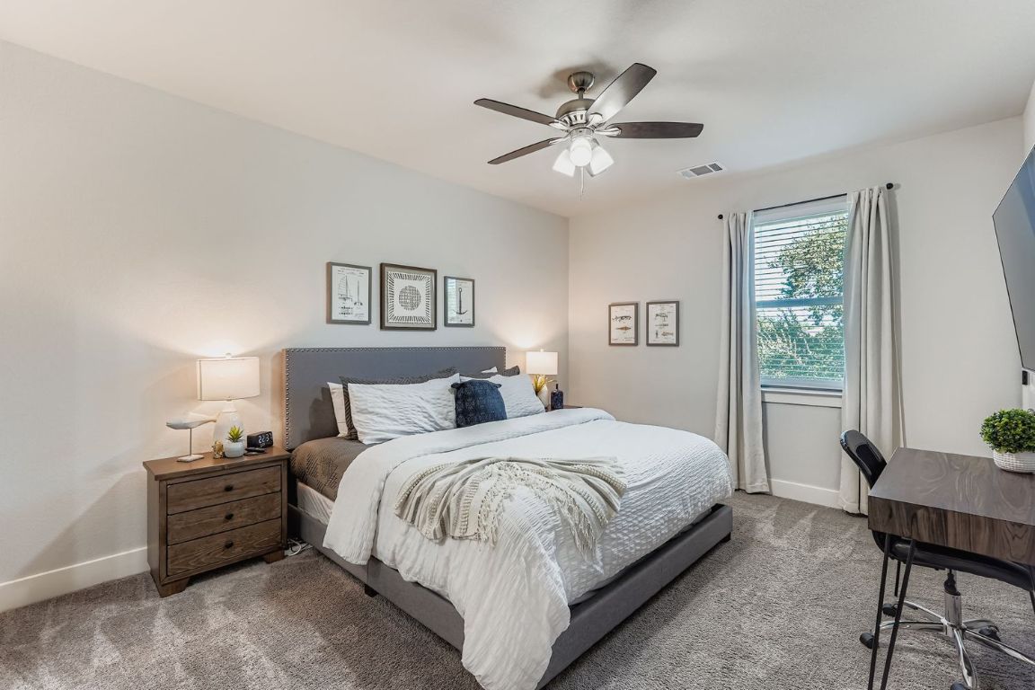 18803 Hogan Circle, Unit 14 Point Venture, TX 78645 - Photo 20 of 40 a bedroom with a large bed and a chandelier