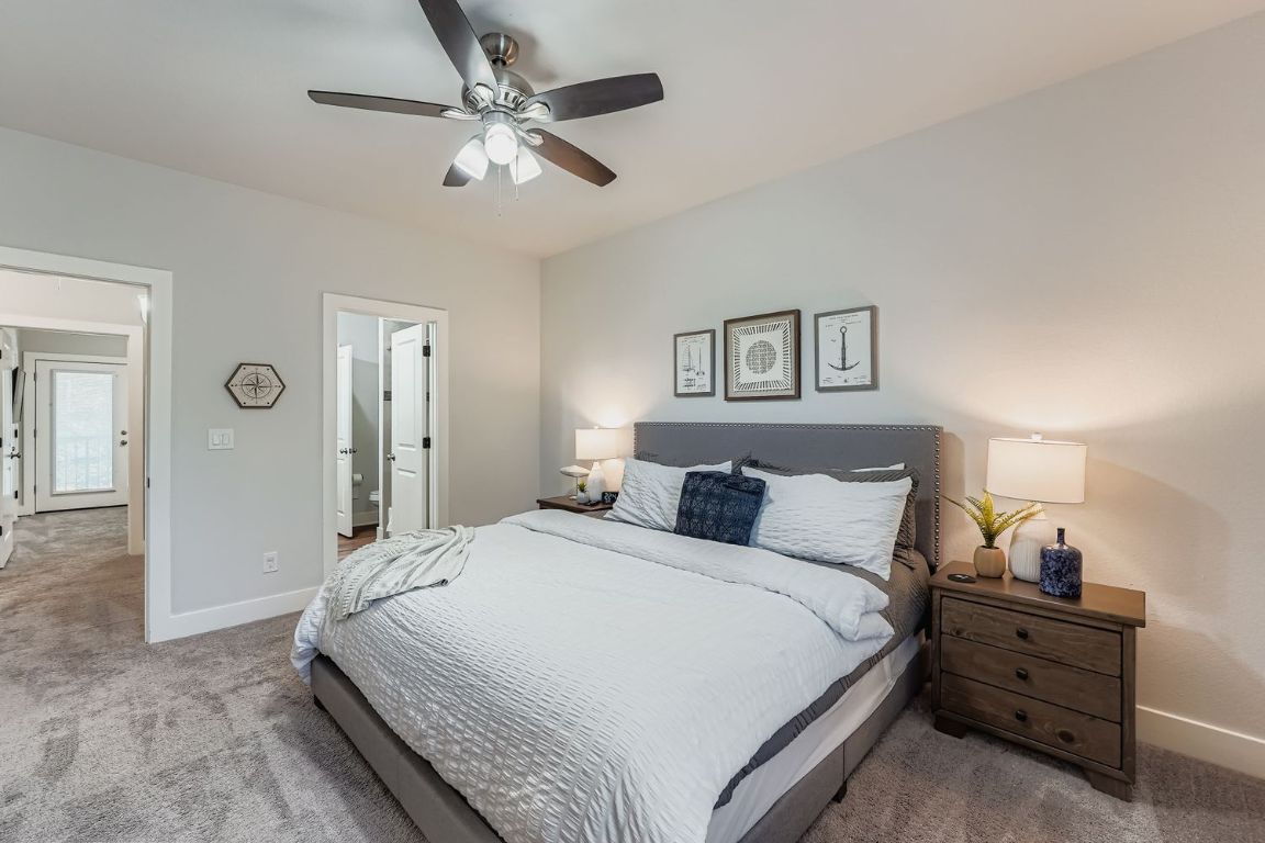 18803 Hogan Circle, Unit 14 Point Venture, TX 78645 - Photo 22 of 40 a bedroom with a bed and a chandelier