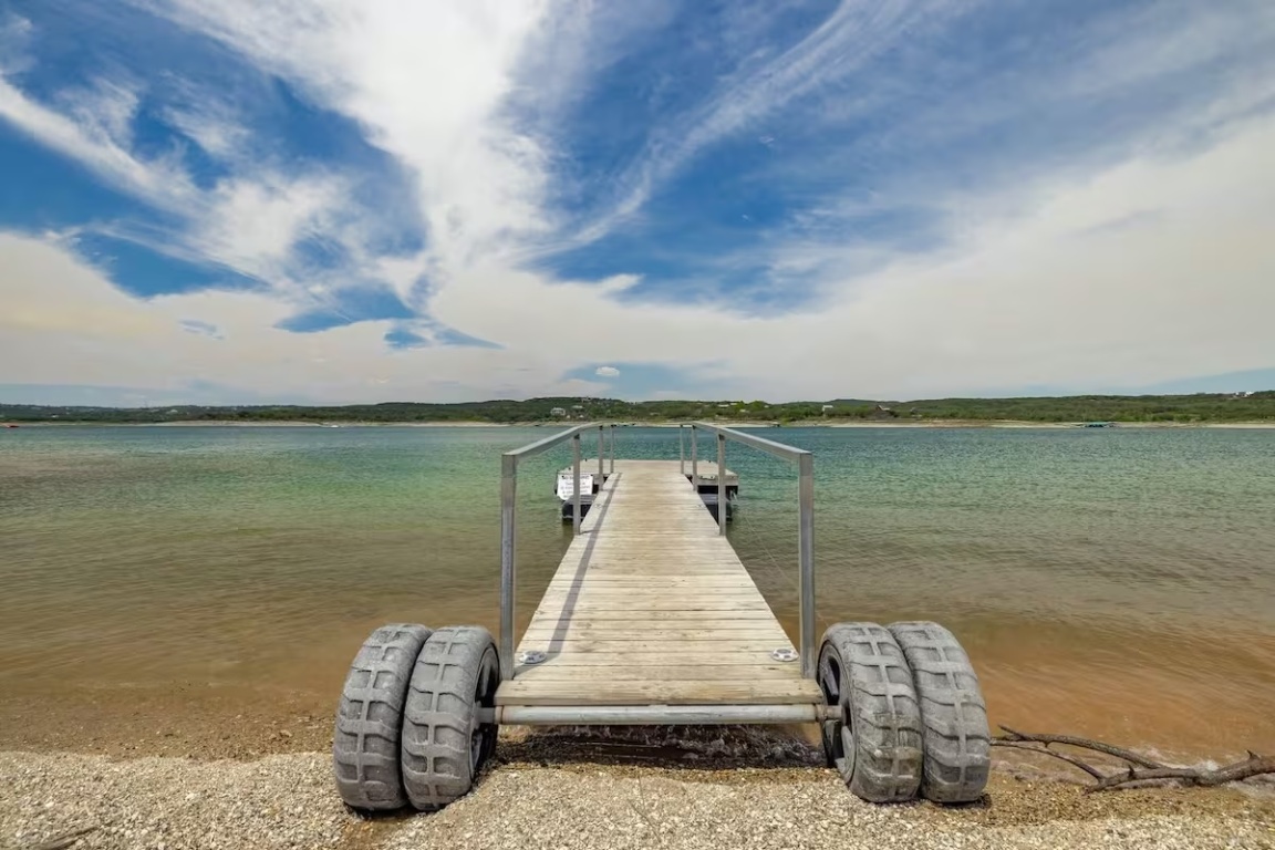 18803 Hogan Circle, Unit 14 Point Venture, TX 78645 - Photo 34 of 40 a wooden bench sitting next to a lake
