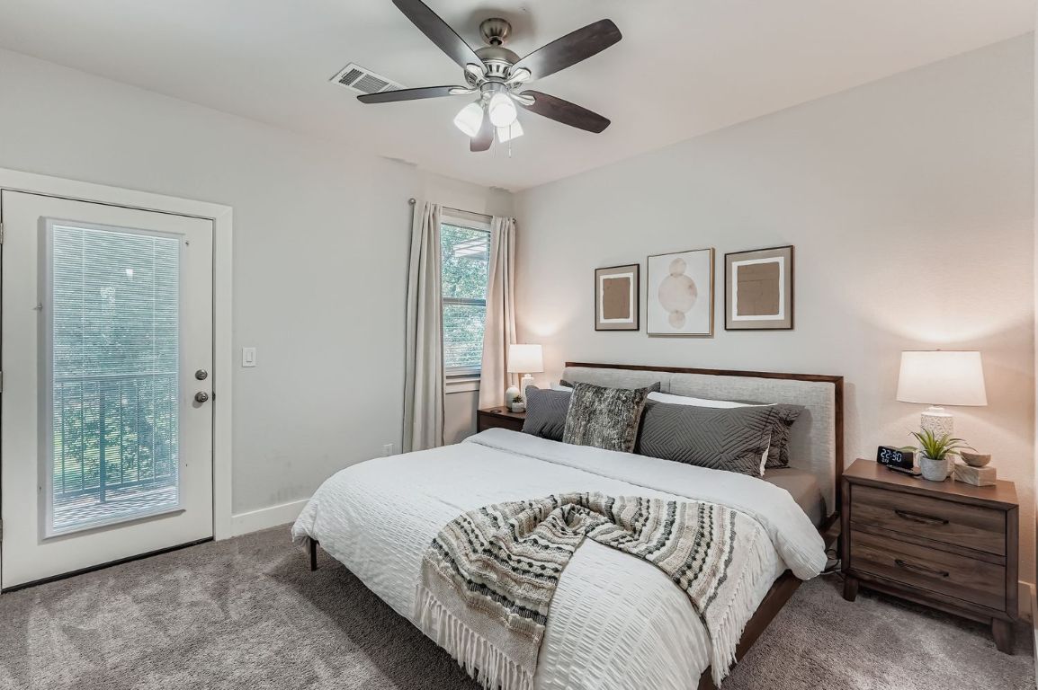 18803 Hogan Circle, Unit 14 Point Venture, TX 78645 - Photo 4 of 40 a bedroom with a large bed and a chandelier