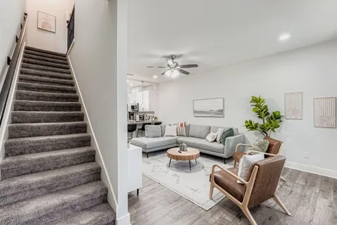 a living room with furniture and stairs
