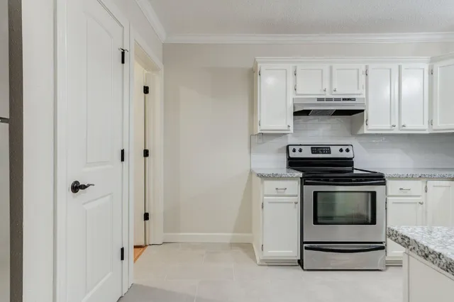 a kitchen with white cabinets and stainless steel appliances
