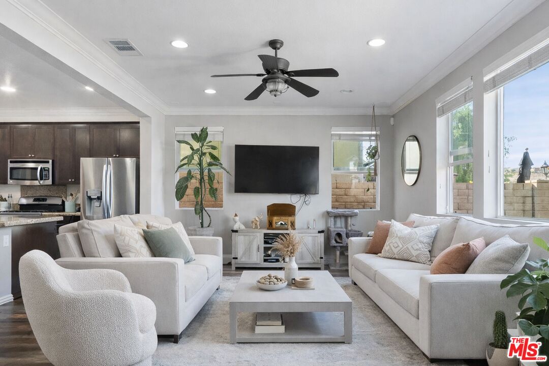 a living room with furniture a flat screen tv and a large window