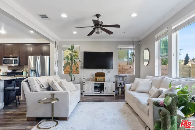 a living room with furniture a flat screen tv and a large window