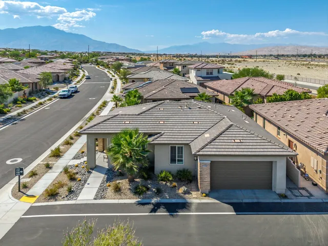 an aerial view of a house with a yard potted plants and large trees