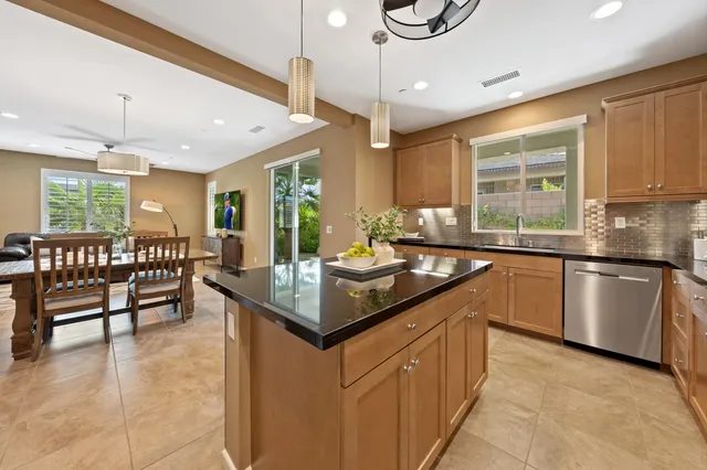 a kitchen with stainless steel appliances granite countertop a sink a stove a microwave a center island and cabinets