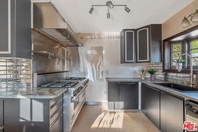 a kitchen with stainless steel appliances granite countertop a sink stove and cabinets