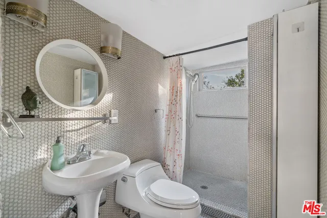 a bathroom with a sink toilet and a mirror
