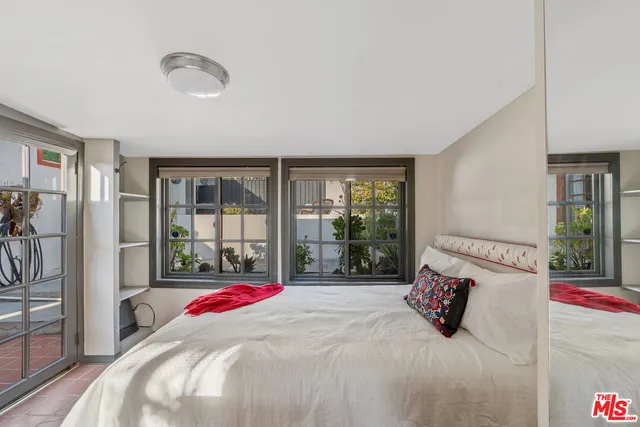a bed sitting in a bedroom next to a large window