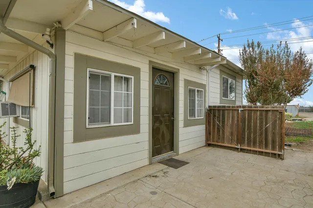 a view of a porch with a door and wooden fence