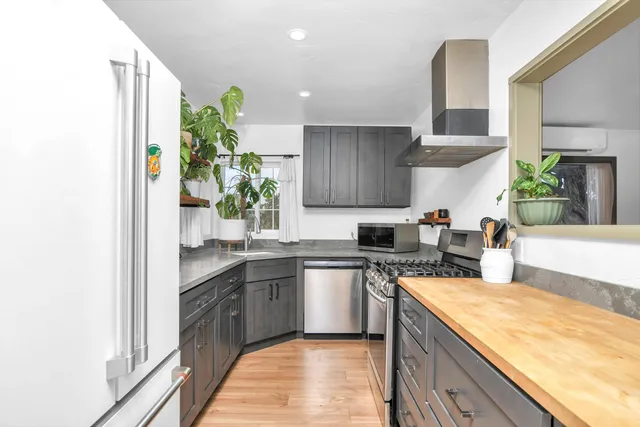 a kitchen with stainless steel appliances granite countertop sink stove top oven and cabinets