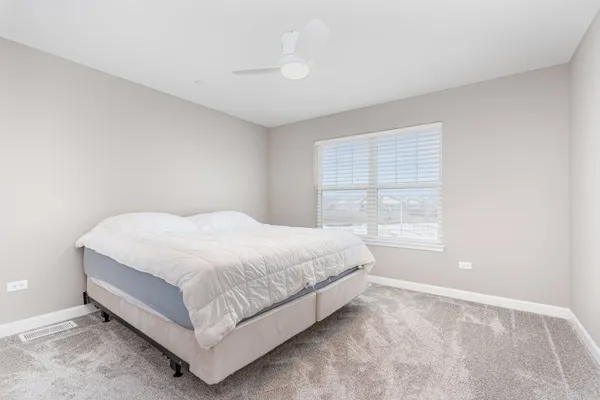 a large bed sitting in a bedroom next to a window