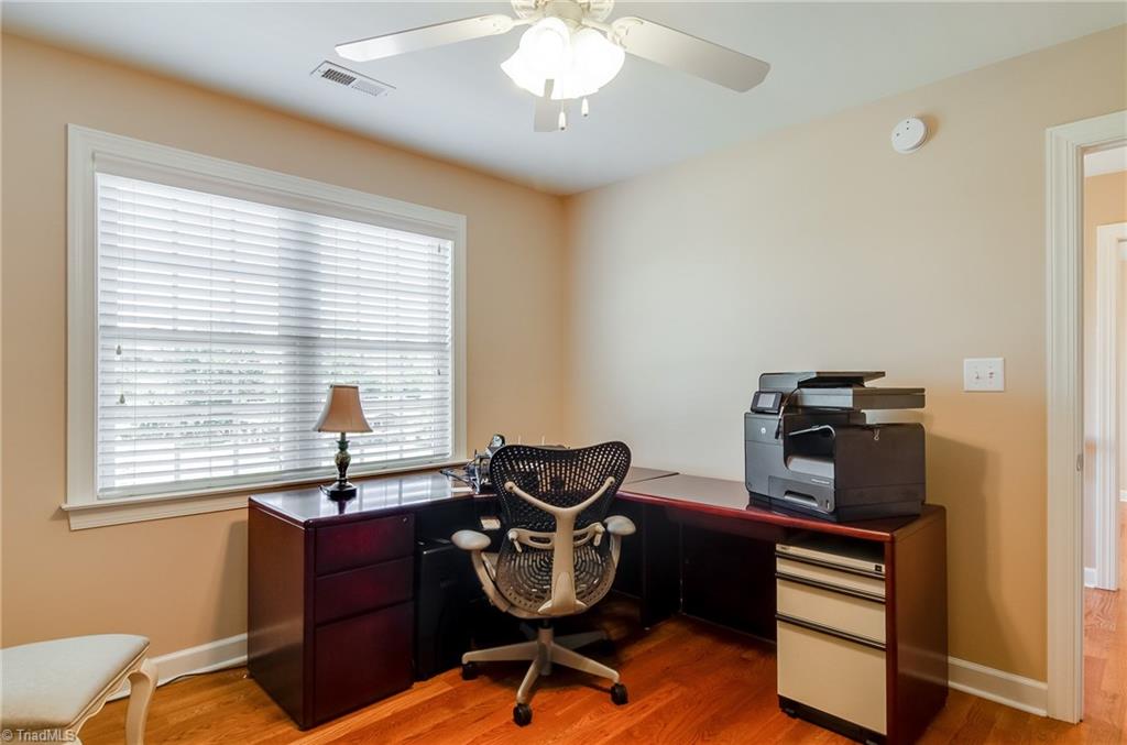 3940 Johnson Street High Point, NC 27265 - Photo 23 of 30 Second bedroom features hardwood floors, ceiling fan, walk in closet, and large window. Bedroom currently being used as an office.