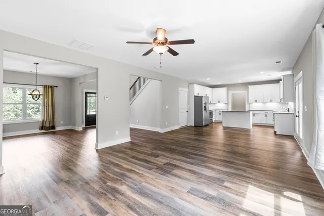 a view of an empty room with wooden floor fireplace and a window