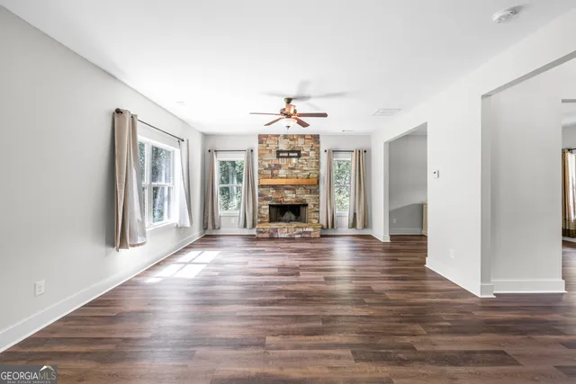 a view of an empty room with window and fire place