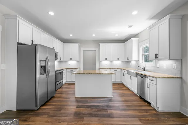 a kitchen with wooden floors and refrigerator