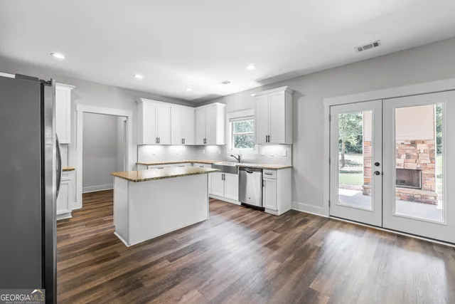 a kitchen with kitchen island granite countertop a stove and a sink