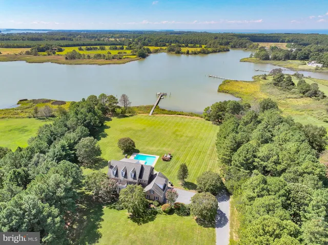 a front view of a house with a yard and potted plants