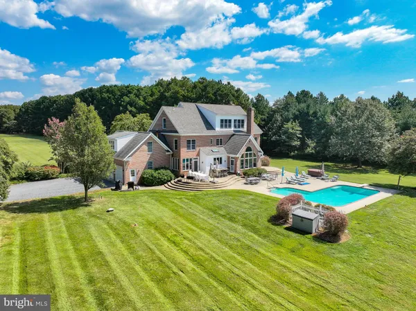 a view of a swimming pool with a patio and a yard
