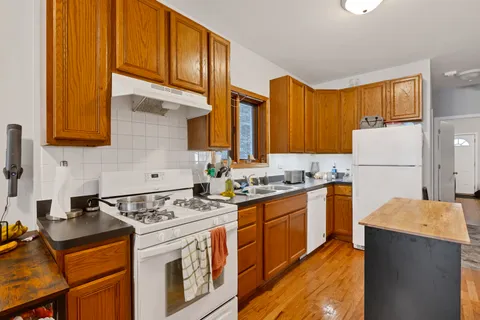 a kitchen with stainless steel appliances granite countertop a stove a sink dishwasher and a refrigerator