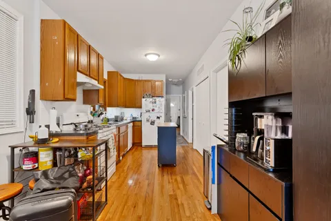 a kitchen with stainless steel appliances granite countertop a refrigerator a stove and a wooden floors
