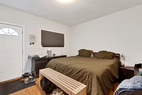 a bedroom with a bed and wooden floor