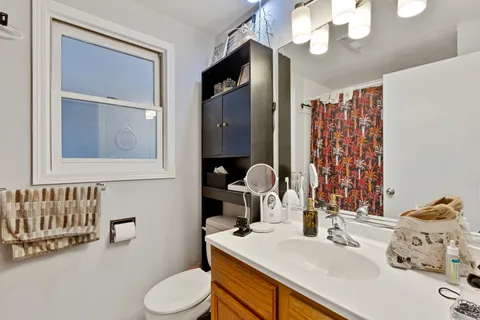 a bathroom with a sink vanity mirror and toilet