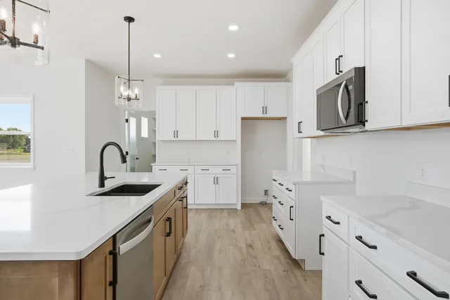 a kitchen with granite countertop white cabinets and stainless steel appliances