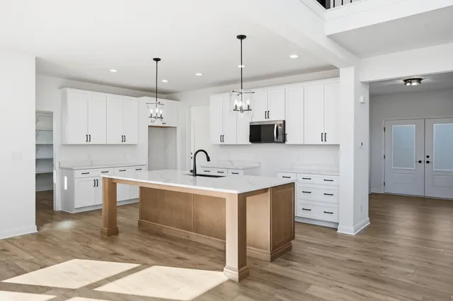 a kitchen with white cabinets stainless steel appliances and kitchen island