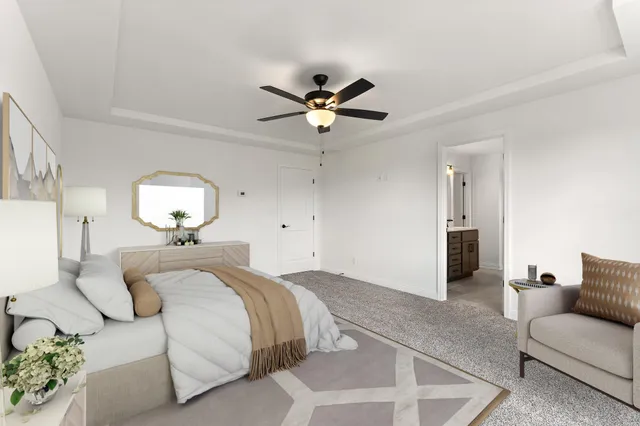 a bed room with a bed couch and a ceiling fan