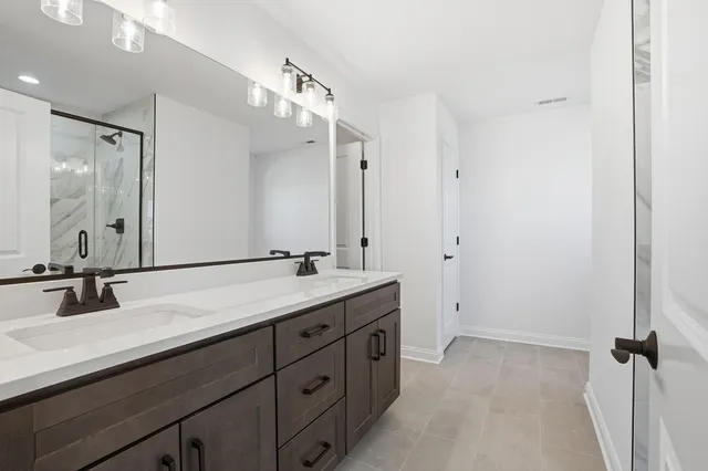 a bathroom with a double vanity sink and mirror with shower