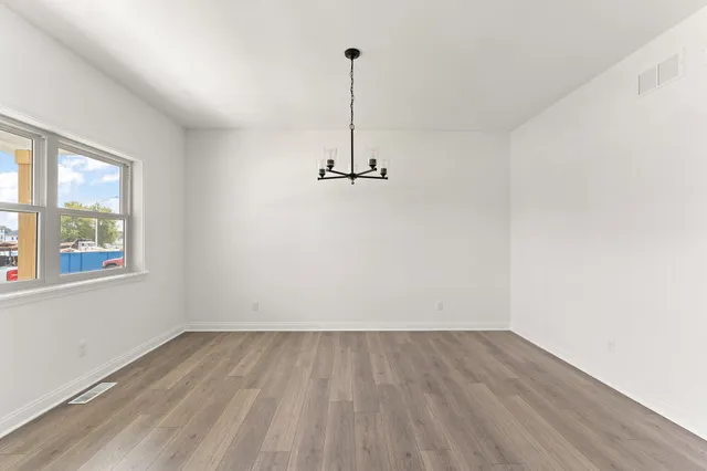 a view of a room with wooden floor and window