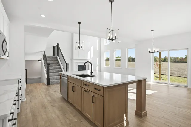 a kitchen with stainless steel appliances kitchen island a hardwood floor and a view of living room
