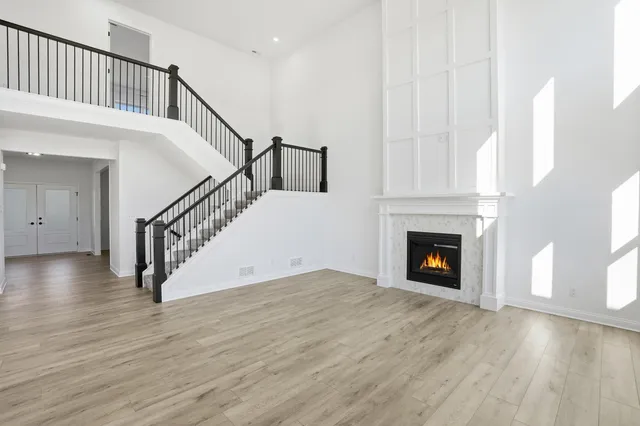 a view of a livingroom with wooden floor staircase and a fireplace
