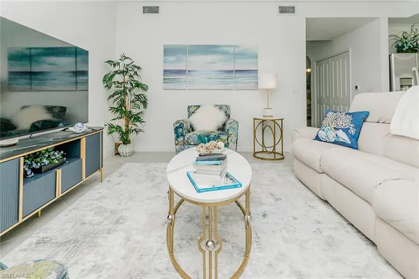 a living room with furniture a potted plant and a fireplace
