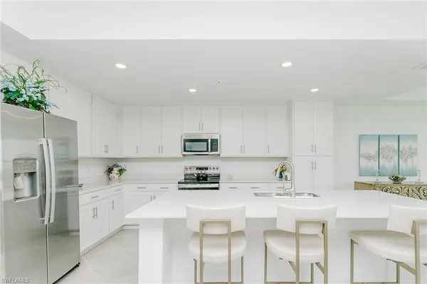 a kitchen with kitchen island a white cabinets and refrigerator