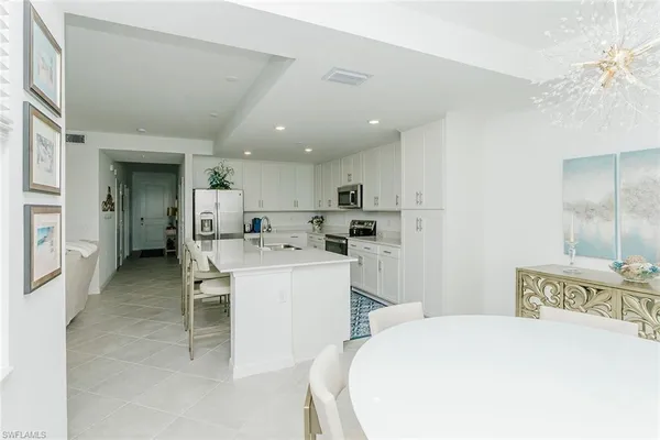 a kitchen with a sink and chairs